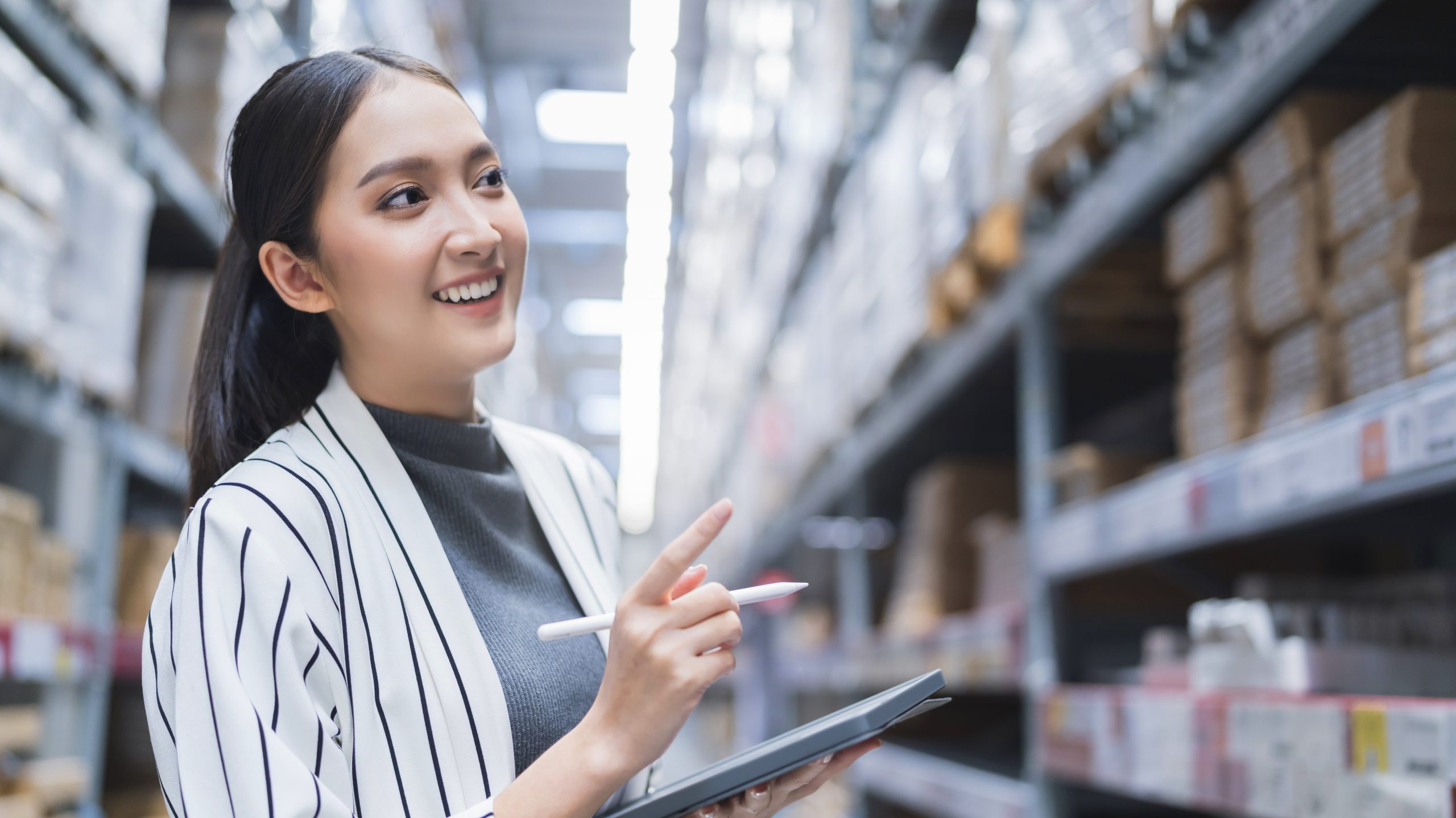 Young business owner setting wholesale prices at a distribution warehouse.