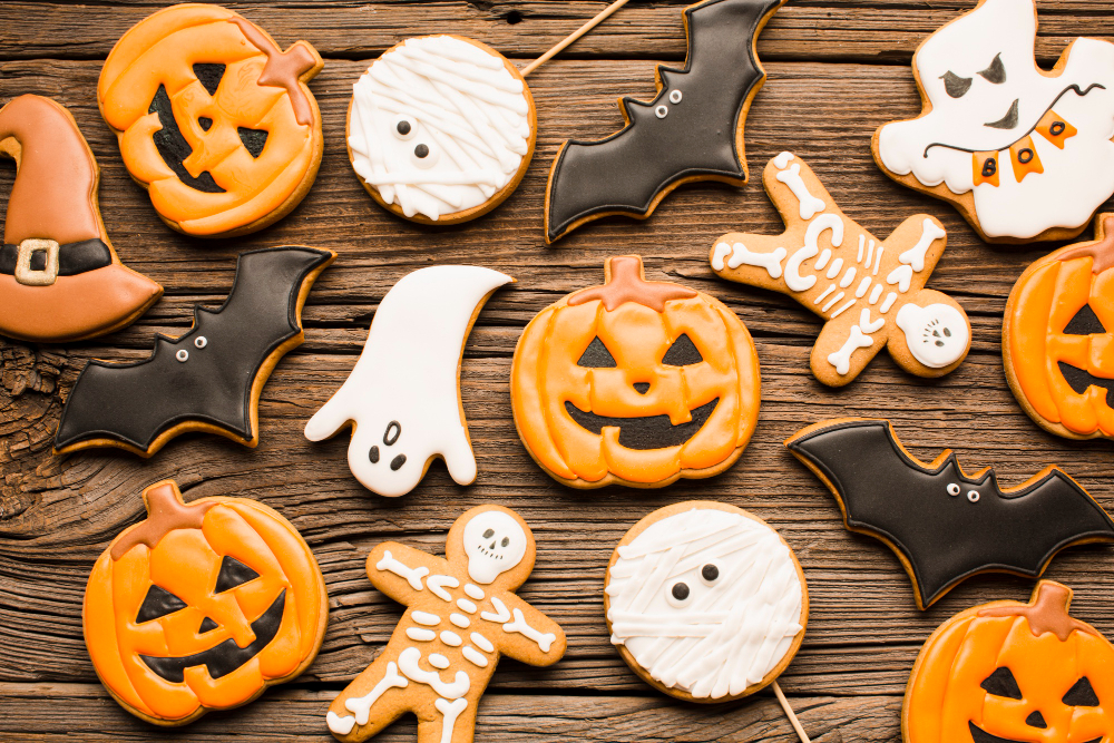 Halloween-themed cookies shaped like pumpkins, ghosts, bats, skeletons, and witch hats