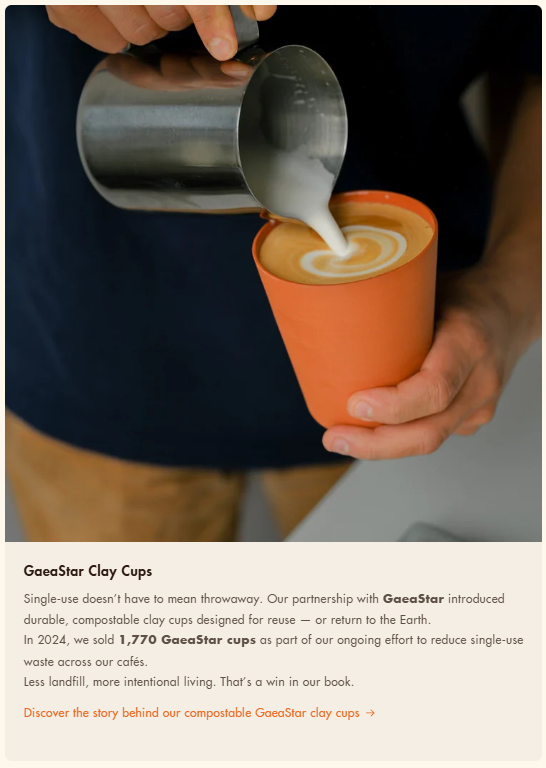 Barista pouring steamed milk into a latte held in an orange GaeaStar compostable clay cup.