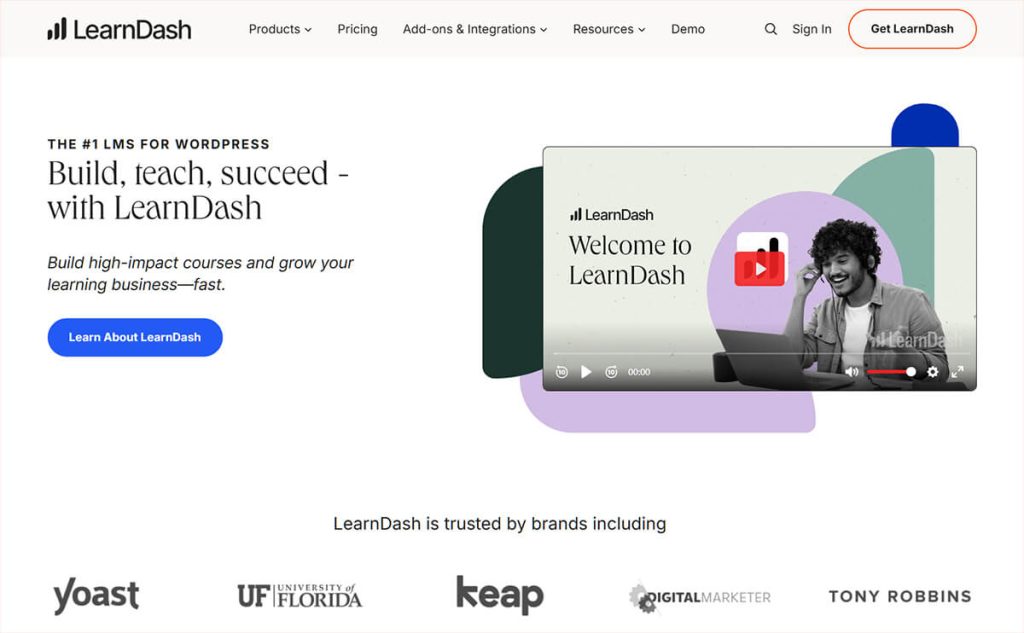 Website hero section for LearnDash LMS showing headline 'Build, teach, succeed,' call-to-action button, and a promotional video thumbnail with smiling person.